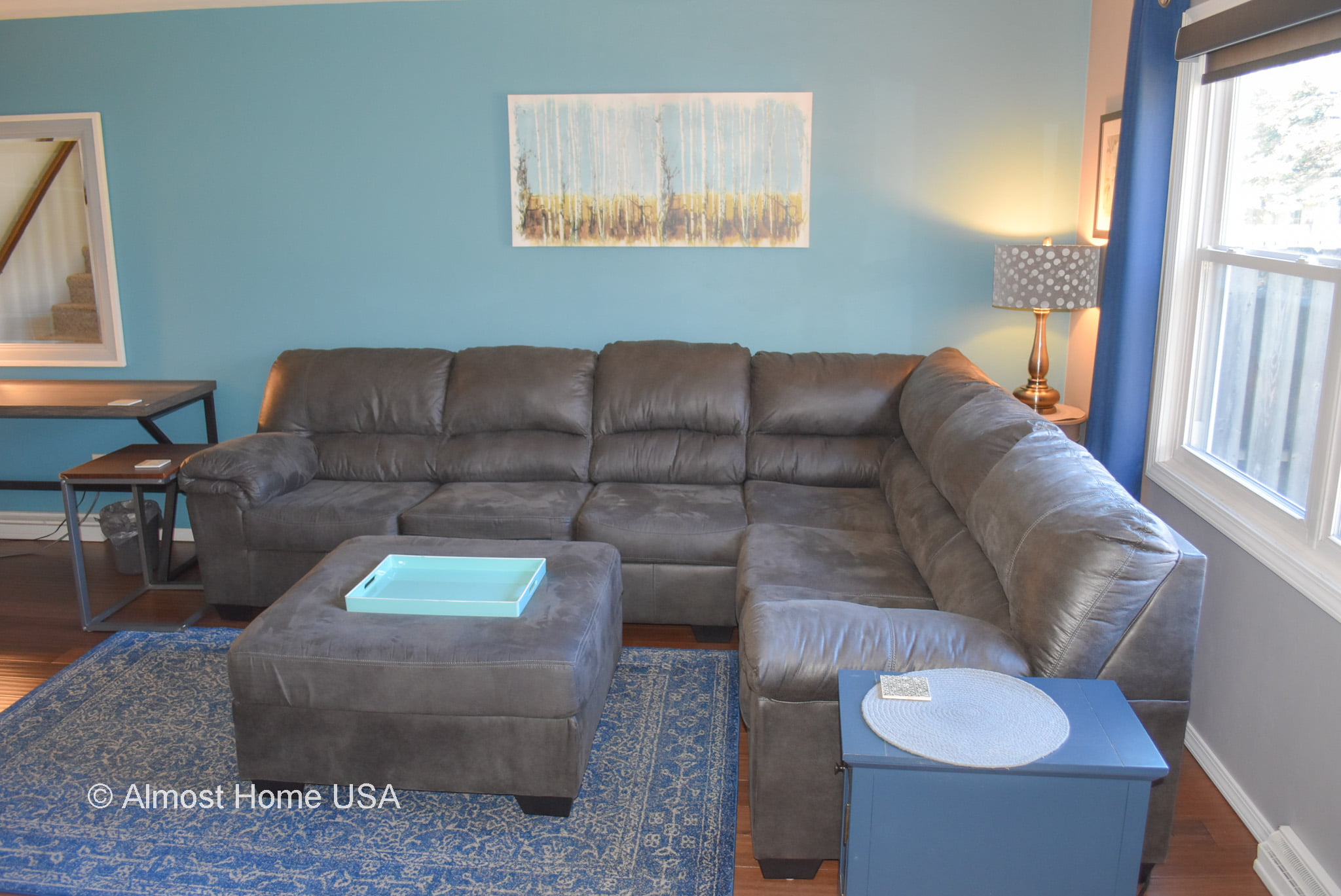 Large sofa and ottoman in furnished three bedroom rental home.